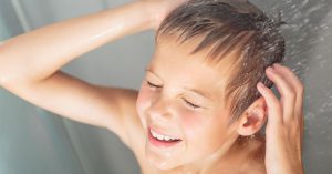 Menino tomando banho no chuveiro para seu novo banheiro