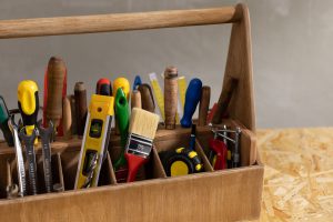 Construction Tools And Toolbox At Wooden Table Background. Tools