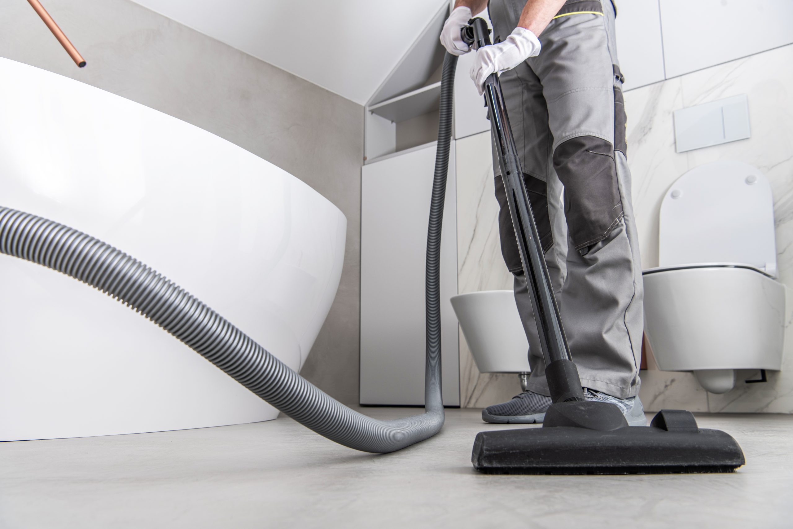 Man Vacuuming White Tile Floor In Bathroom 2022 12 16 11 49 47 Utc