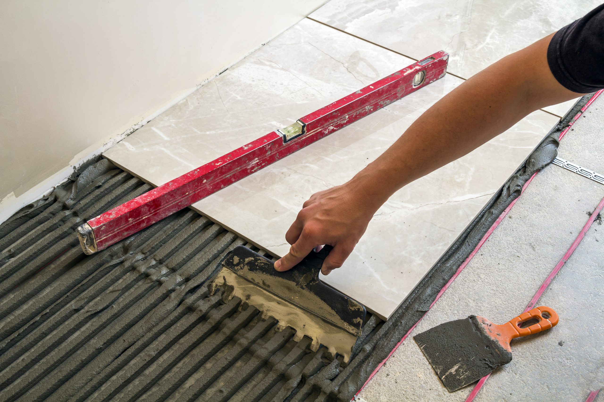 Ceramic Tiles And Tools For Tiler. Worker Hand Installing Floor Tiles. Home Improvement, Renovation Ceramic Tile Floor Adhesive, Mortar, Level.