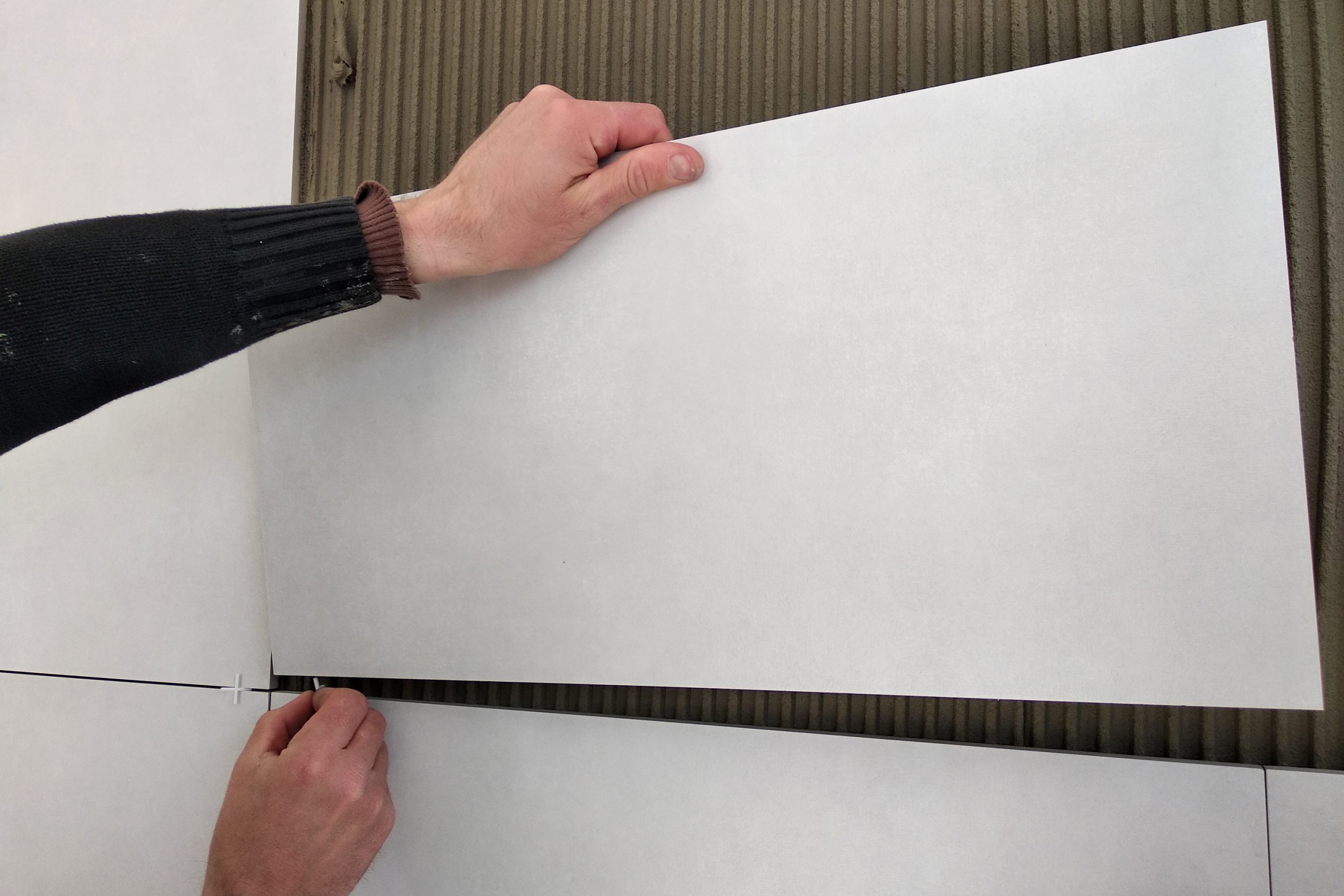 Worker Hands Putting Ceramic Tiles On The Wall.