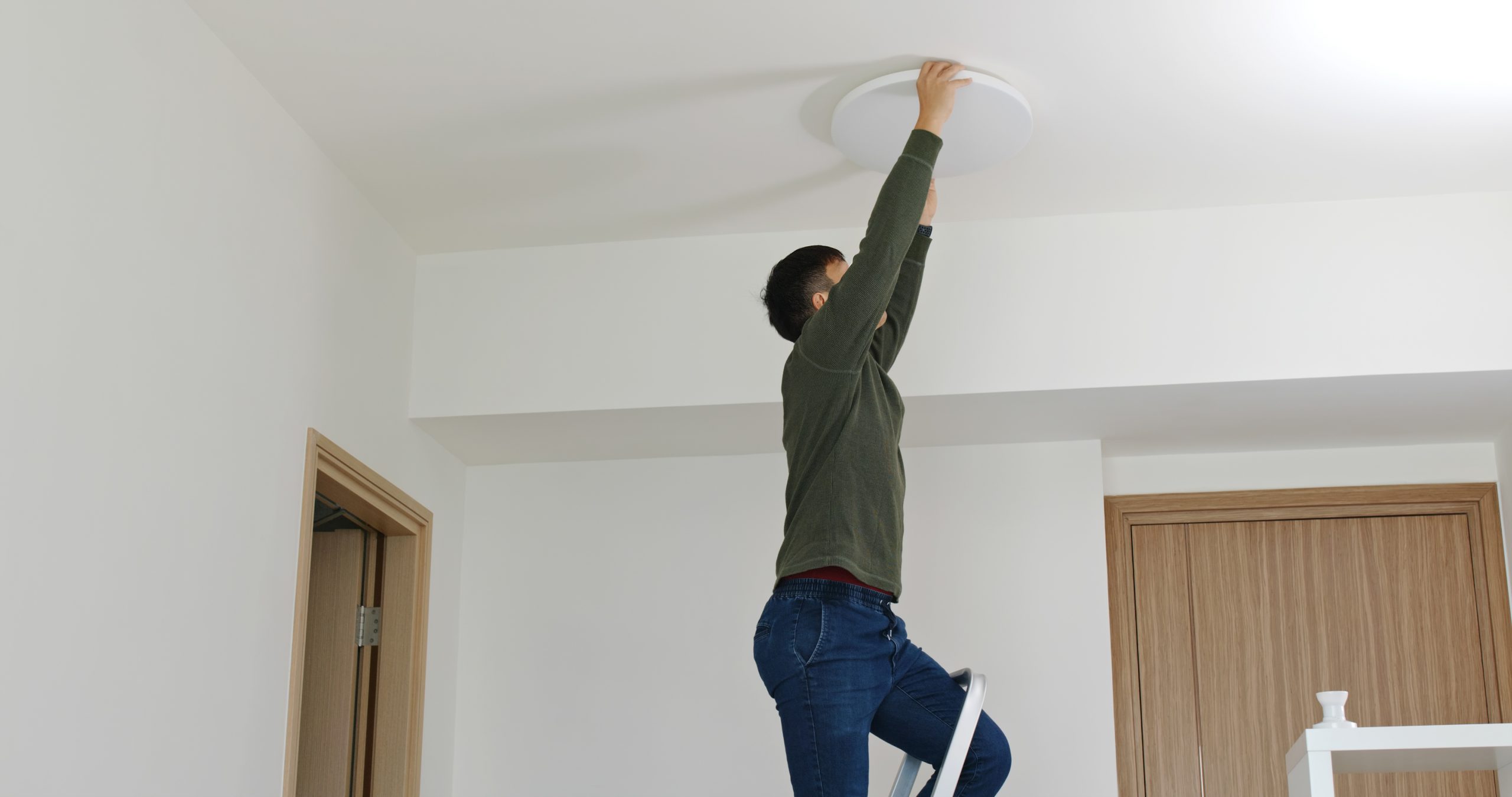Man Install Lamp Onto The Ceiling At Home
