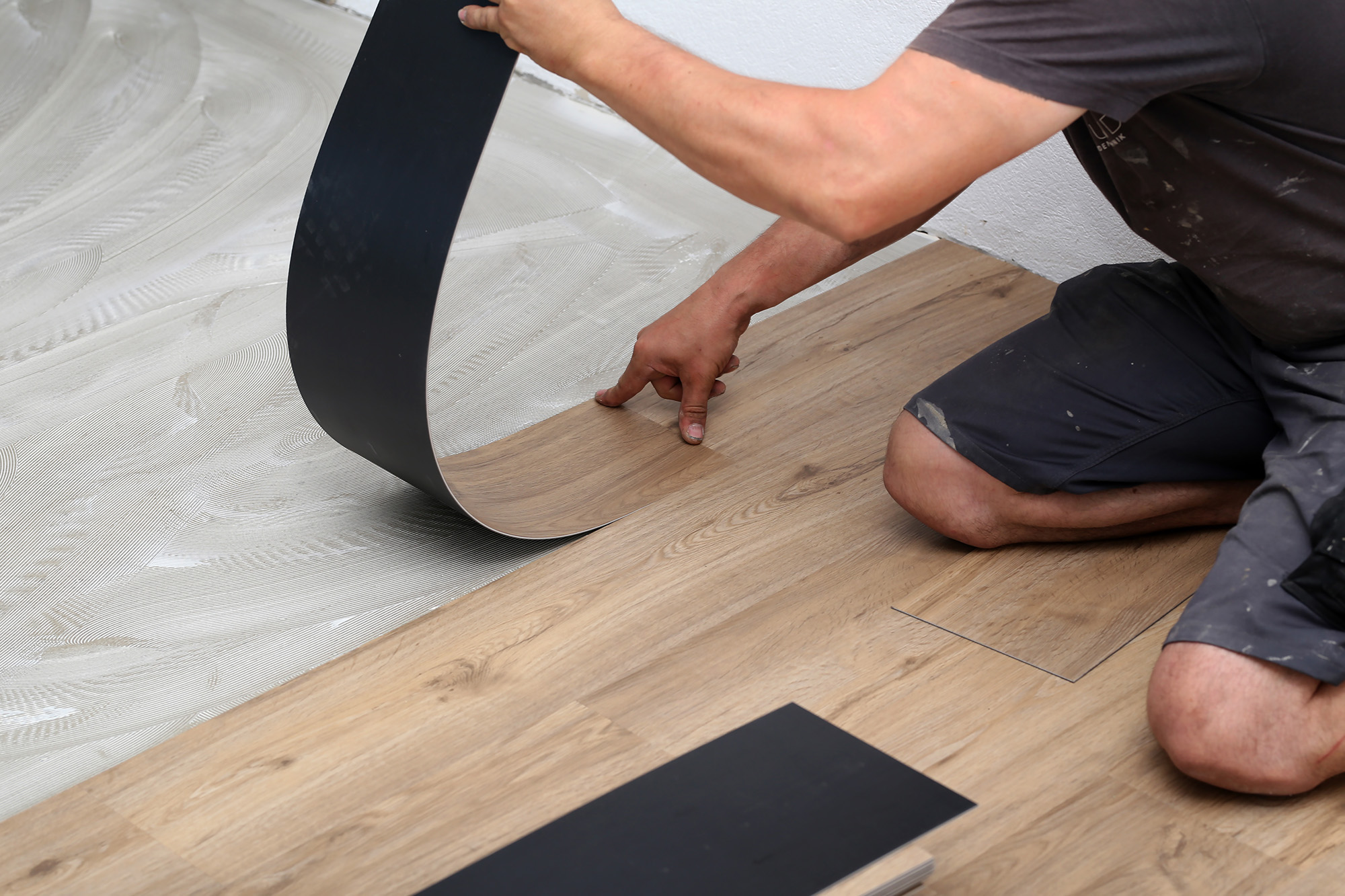Worker Installing New Vinyl Tile Floor