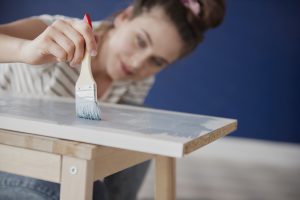 Close Up Of Young Woman Repainting Old Furniture