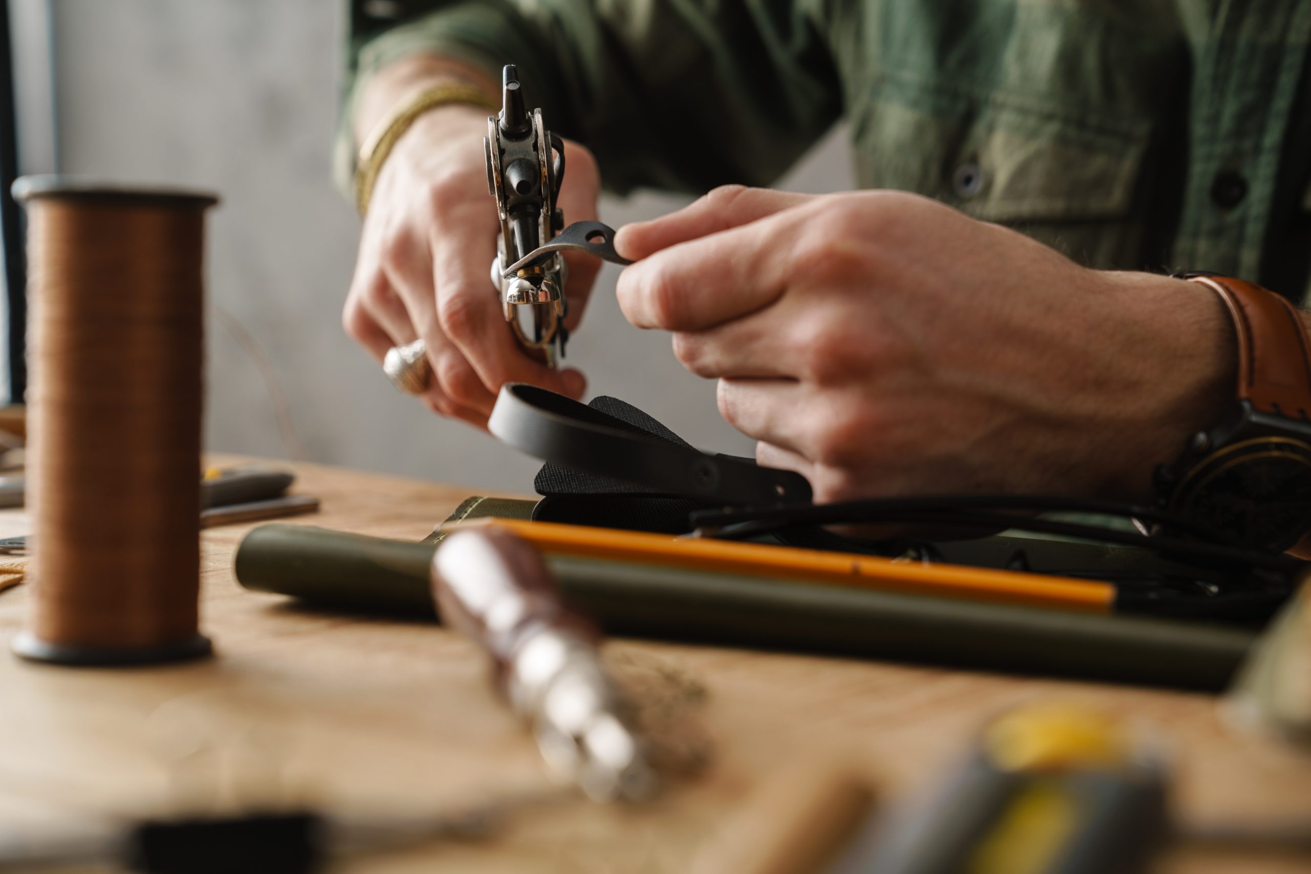 White Craftsman Using Tool While Working With Leather In Workshop